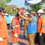 Plt. Sekda Kalteng Leonard S. Ampung saat melakukan penyematan secara simbolis alat pelindung diri kepada personel tim PDKB PLN UID Kalselteng. Foto : Ist